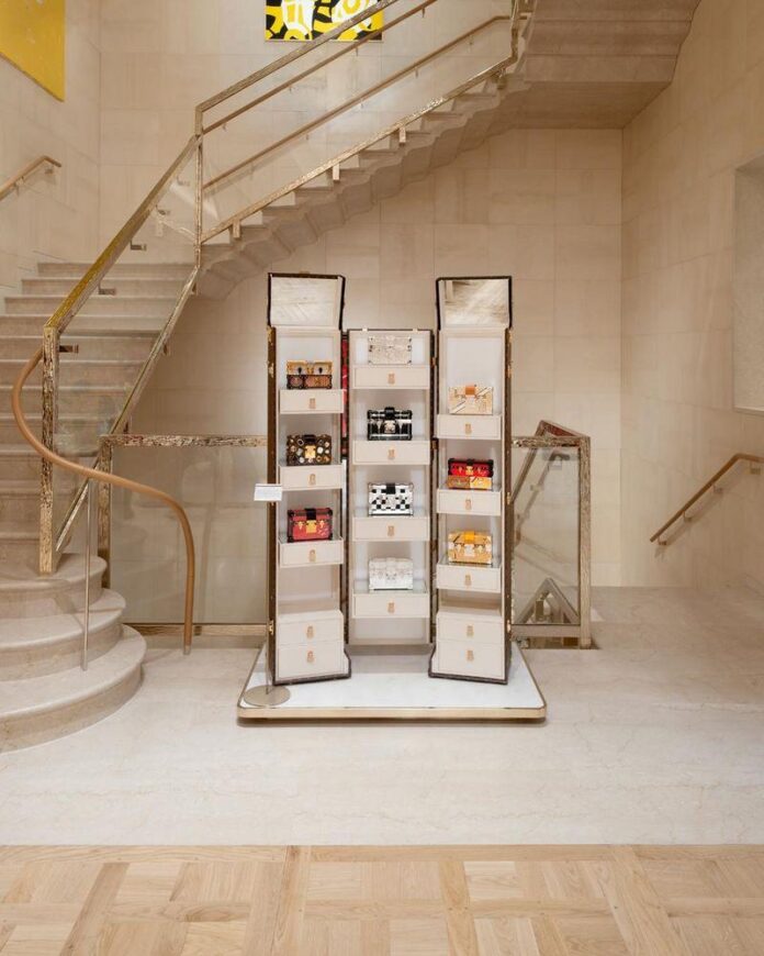 Ambiente interno da loja da Louis Vuitton, decorado com paredes em tons claros e uma escada elegante.