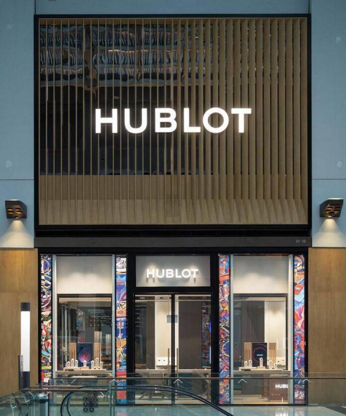 Exterior atualizado da boutique Hublot, destacando elementos de madeira e vidro.