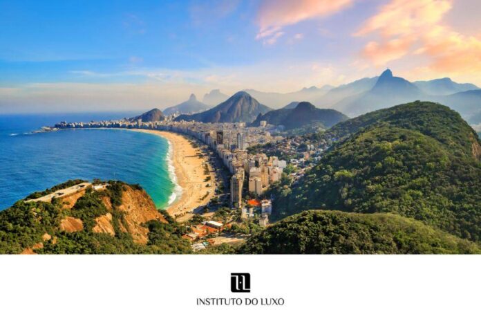 Imagem do mercado de luxo no Brasil com paisagem costeira e montanhas ao fundo, destacando uma praia extensa e edifícios ao longo da costa.