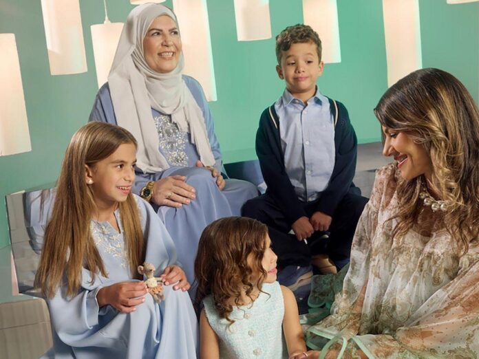Imagem mostra um ambiente decorado para o Ramadan, com pessoas sorridentes vestindo trajes tradicionais.