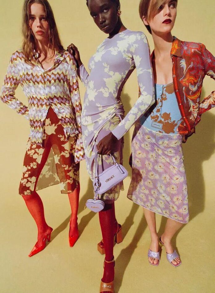 Imagem que retrata o rachat da casa de luxo Versace pelo grupo Prada, destacando as cores vibrantes e as estampas florais das roupas apresentadas.