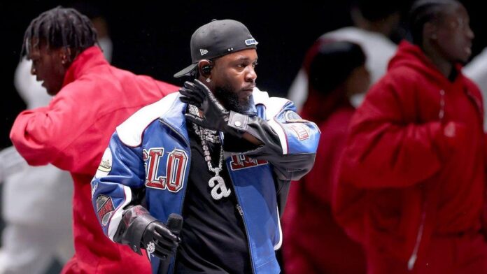 Kendrick Lamar usando um casaco de couro desenhado por sua empresa criativa pgLang durante o show do intervalo do Super Bowl LIX.