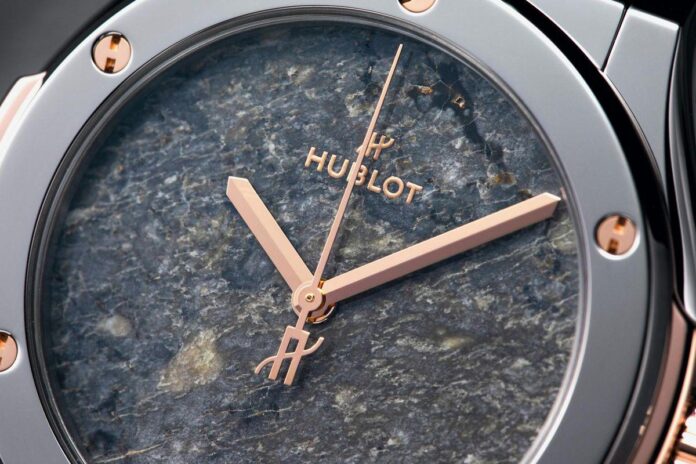 Mostrador em pedra azul, com ponteiros rosé e marca Hublot em destaque.