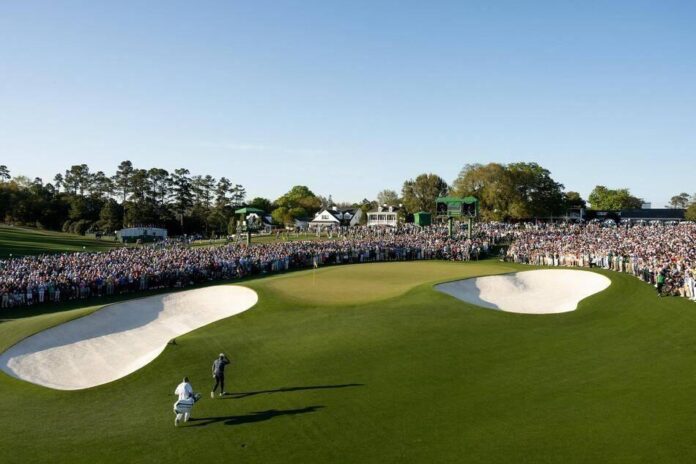 Uma multidão de pessoas assistindo a um evento esportivo em um campo de golfe.