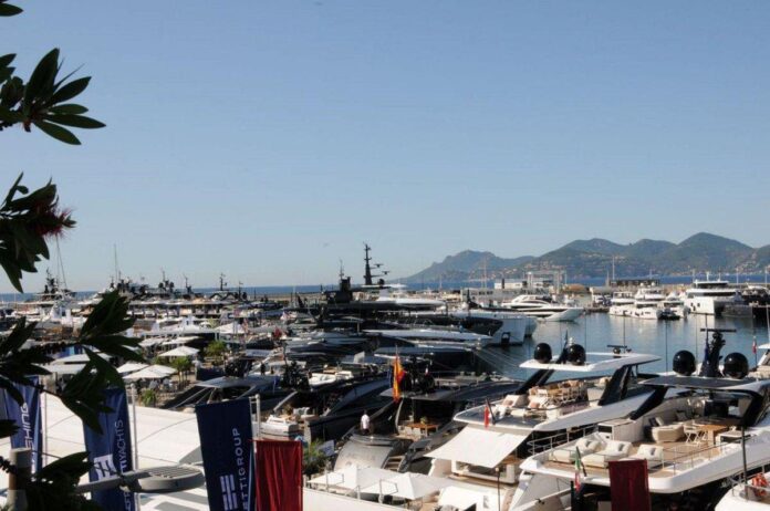 Visão lateral do Old Port com iates e a cidade ao fundo na exibição principal do Cannes Yachting Festival 2024.